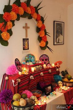 a table topped with lots of food next to a cross and pictures on the wall