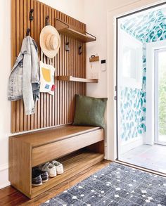 a wooden bench sitting in front of a sliding glass door next to a blue rug