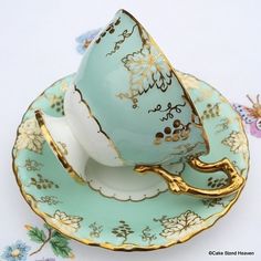 an antique tea cup and saucer with gold trim