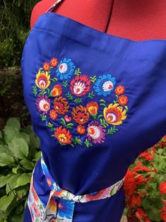 a woman's blue dress with colorful flowers on it