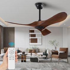 a person is holding a remote control in front of a ceiling fan that's turned on