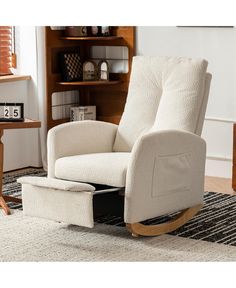 a rocking chair with a footstool in front of a book shelf