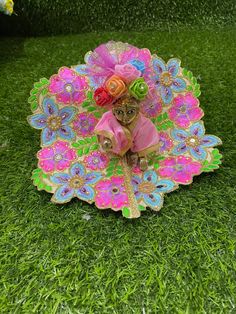 a small figurine sitting on top of a green grass covered field next to flowers