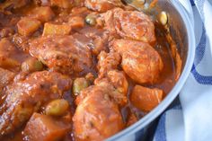 meat and vegetable stew in a pan on a towel