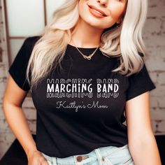 Introducing our Marching Band Mom t-shirt, perfect for high school band moms! The minimalist design features repeating font of "Marching Band" in white text on a black t-shirt and has optional customizable text underneath. Made with high-quality materials, this t-shirt is comfortable and durable for everyday wear. Show off your pride for your child's passion with this stylish and eye-catching t-shirt. Order now and become the ultimate Marching Band Mom!

Slight variances in color and size are no Black Band Merch T-shirt With Name Print, Band Merch T-shirt With Name Print, Band Merch T-shirt With Name Print In Cotton, Marching Band Mom, Band Mom, High School Band, School Band, Fan Shirts, Marching Band