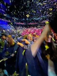 a group of people standing next to each other under confetti falling from the sky