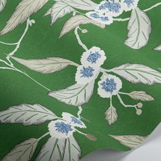 a green and white wallpaper with blue flowers on it's side, including leaves