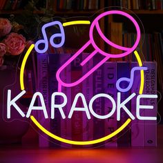 a neon sign that reads karaoke with a microphone in the center and books behind it