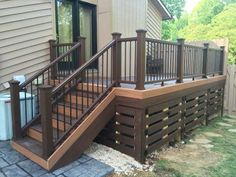 a wooden deck with railings next to a house