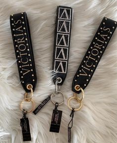 three lanyards with name tags on them sitting on a white furnishing