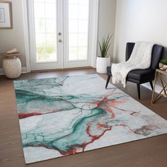 a living room area with a rug, chair and potted plant on the floor