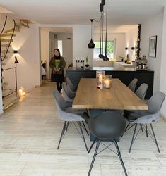 a dining room table with grey chairs and an island in the middle is surrounded by white tile flooring