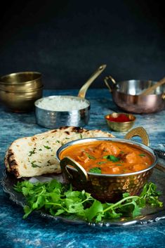 a bowl of soup and some bread on a table