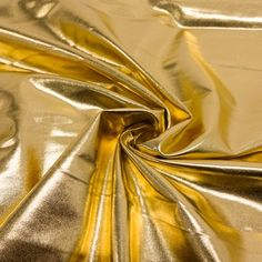 a shiny gold fabric is shown in close up view, it looks like metallic foil