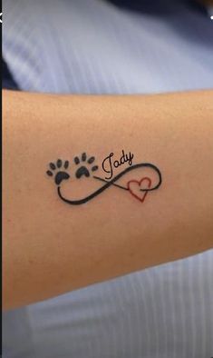 a person with a tattoo on their arm that has a dog's paw and heart