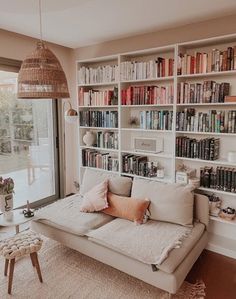 a living room filled with furniture and bookshelves next to a large glass window