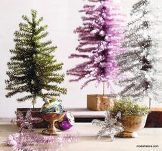 three small christmas trees sitting on top of a table