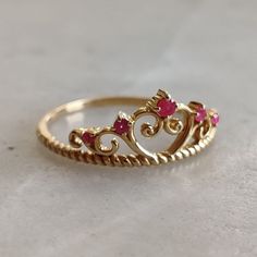 ITEM DESCRIPTION: >>The ring is made from Solid 14K Yellow Gold.  >>Gemstone used is absolutely natural and ethically sourced.  >>Natural Ruby in prong setting and crown shape design is studded on it with utmost precision.  Gem: Ruby Gem size and shape: 2.00 mm and round Gem size and shape: 1.50 mm (2pc) and round Gem size and shape: 1.10 mm (2pc) and round Gem weight: 0.09 carats Gold purity: 14K (58.33% approx.) Gold weight: 1.62 grams Total weight of ring: 1.64 grams The Gold purity is guaranteed and it comes with authentic 14K gold hallmark. Since these Rings are handmade, they are Nickel/Lead FREE.  CUSTOMIZATION: >>Size Customization is available for this ring and it is available in all ring sizes. >>Gemstone customization is also available and the main gemstone can be substituted wi Unique 14k Gold Ruby Ring As Gift, Unique 14k Gold Ruby Ring For Anniversary, Unique 14k Gold Birthstone Promise Ring, Exquisite 14k Gold Ruby Ring Gift, Luxury 14k Gold Ruby Birthstone Ring, Elegant 14k Gold Rings For Birthday, 14k Yellow Gold Rings For Birthday, 14k Gold Ruby Ring, Natural Ruby Ring