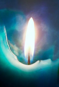 a candle is lit in the middle of a dark room with blue and green lighting