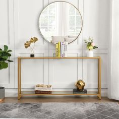 a living room with white walls and a gold console table