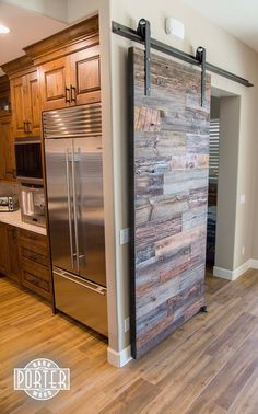 a stainless steel refrigerator in a kitchen next to a wooden paneled wall and cabinets