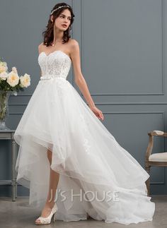 a woman in a wedding dress standing next to a chair