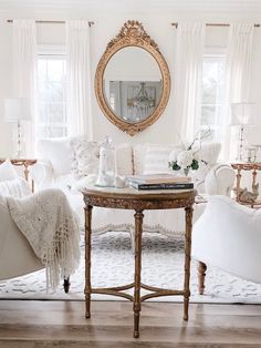 a living room filled with furniture and a round mirror on the wall over a coffee table