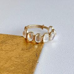 18KT yellow gold ring with oval, genuine moonstone, bezel-set. Great for stacking, anniversary, or as a wedding band! Weight: 2.40 grams Adjustable sizing bar in back, but we can also do up in any size and with other gemstones. Please inquire (7) Genuine, oval-cut Cabochon moonstone measures: 6mm x 4mm 3.40 carats of moonstones Stamped 18K Eternity Band Ring, Yellow Gold Ring, Eternity Band, Moon Stone, Eternity Bands, Bezel Setting, Yellow Gold Rings, Oval Cut, Band Ring