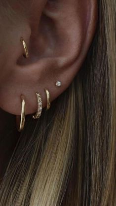 a woman's ear with three different types of piercings