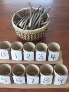 a wooden table topped with lots of cups filled with magnets and numbers on them