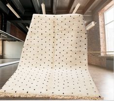 a large white rug with black dots on it