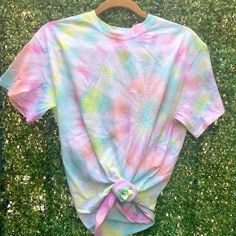 a tie - dyed shirt is laying on the grass