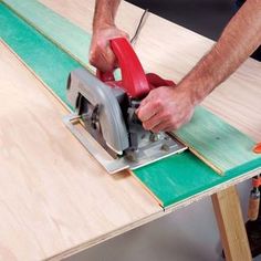 a man using a circular saw to cut plywood planks with a jig