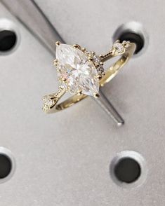 a diamond ring sitting on top of a piece of metal