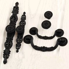 an assortment of black handles and knobs on a white surface with numbers in the middle