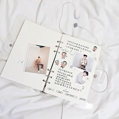 an open book with pictures on it sitting on top of a white sheet covered bed