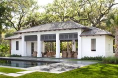 the pool house is surrounded by trees and grass