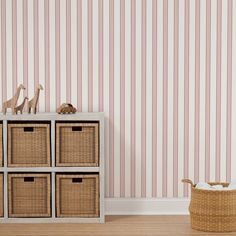 an empty room with toy animals and baskets on the floor next to striped wallpaper