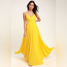 a woman in a yellow dress posing for the camera