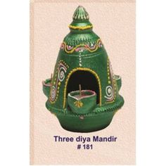 a small green pot sitting on top of a wooden table next to a sign that says three diya mandir