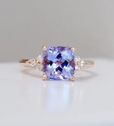 "Cushion lavender tanzanite engagement ring and matching bands. Rose gold engagement ring bridal set. Eidelprecious ring. The ring features lavender cushion Tanzanite, 2.7mm, 8x8mm. The cut is mesmerising, making the stone sparkle like crazy. The color is fantastic. It is a blend of lavender, blue and violet. It changes constantly depending on the lightening and shines all over the place. The tanzanite is set in our bestseller, Campari setting 14k rose gold, Si/H diamonds. Ready to ship. The set Lavender Diamond Engagement Ring, Rose Gold Tanzanite Ring, Aquamarine And Amethyst Ring, Natural Sapphire Ring, Tanzanite Engagement Rings, Lavender Engagement Ring, Square Cut Engagement Ring, Tanzanite Ring Engagement, Lavender Sapphire Engagement Ring