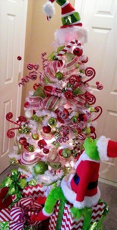 a christmas tree decorated with candy canes and santa claus's hat on top