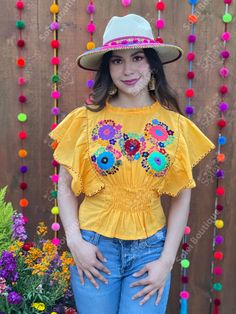 This beautiful Flounce Sleeve Top is the perfect Top for a fun day out or special event. The adorable fluttery sleeves and colorful hand embroidered flowers make it flirty and fun. It's made out of fine Mexican cotton, has an elastic waist and has colorful flowers embroidered completely by hand. This blouse is made with love by Mexican Artisans in Chiapas, Mexico. Please note: This blouse comes in one size which fits sizes Small and Medium. Purchase the Mexican hats here: https://www.etsy.com/es Yellow Folk Style Blouse For Spring, Yellow Folk Style Spring Blouse, Yellow Bohemian Tops For Festivals, Yellow Festive Tops For Summer, Festive Yellow Summer Tops, Yellow Bohemian Tops For Festive Occasions, Festive Bohemian Yellow Tops, Festival Embroidered Yellow Blouse, Multicolor Fitted Peasant Top For Summer