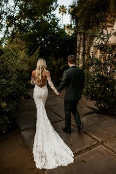 the bride and groom are holding hands