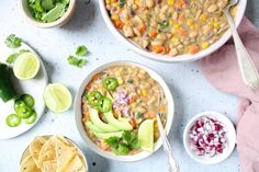 two bowls filled with beans, avocado, and other vegetables next to tortilla chips