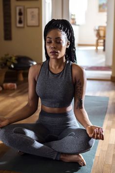 a woman sitting in the middle of a yoga pose