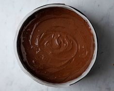 a white bowl filled with chocolate frosting on top of a table