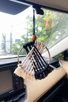 the interior of a car with a hanging object in it's dash board holder