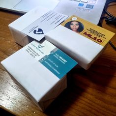 several business cards are stacked on top of each other in front of a laptop computer