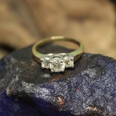 three stone ring sitting on top of a rock